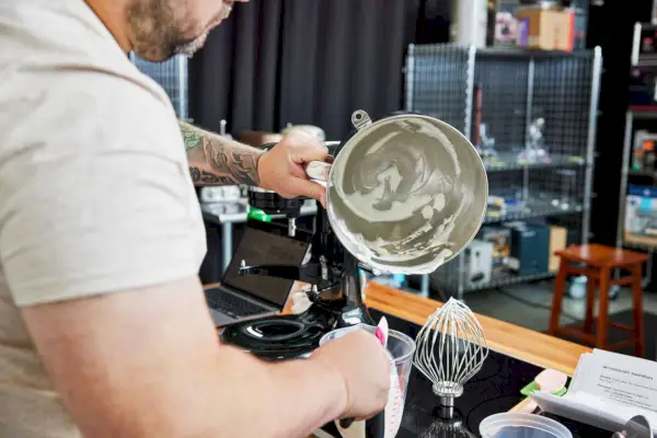 אדם מסיר קצפת ממיקסר סטנד 7-Quart Bowl-Lift מסדרת KitchenAid Pro Line