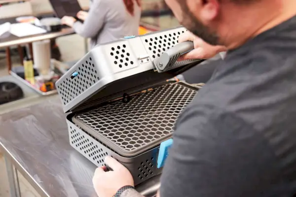 אדם שפותח את NOMAD Grill & Smoker