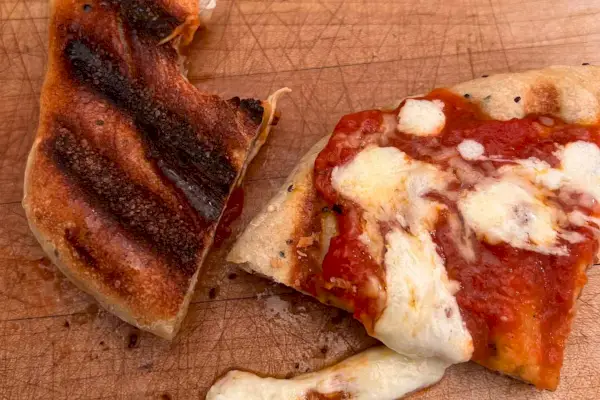 Pizza vyrobená na Cuisinart Elite Griddler je umístěna na dřevěné desce