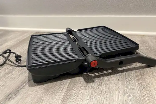 Chefman Electric Panini Press Grill se otevřel a je zobrazen na dřevěné podlaze