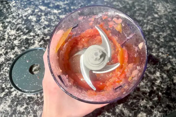 Osoba držící Ninja Express Food Chopper s naskočeným jídlem v něm