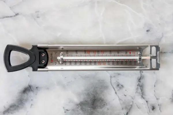 Termometr do cukierków ze stali nierdzewnej Taylor Precision Products ustawiony na marmurowym blacie