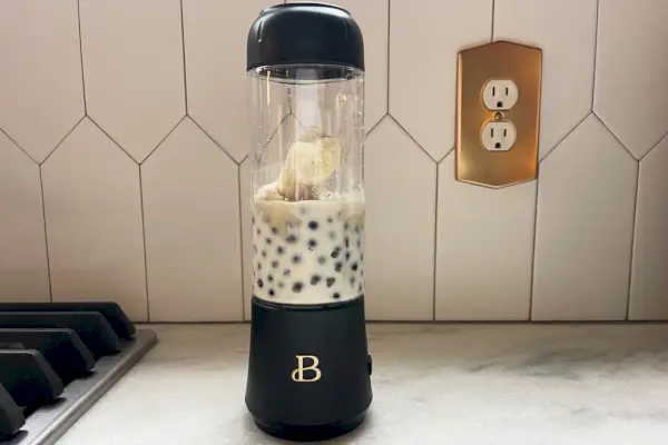 Beautiful by Drew Barrymore Portable To-Go Blender 2.0 na mramorovej kuchynskej linke s prísadami na smoothie vo vnútri