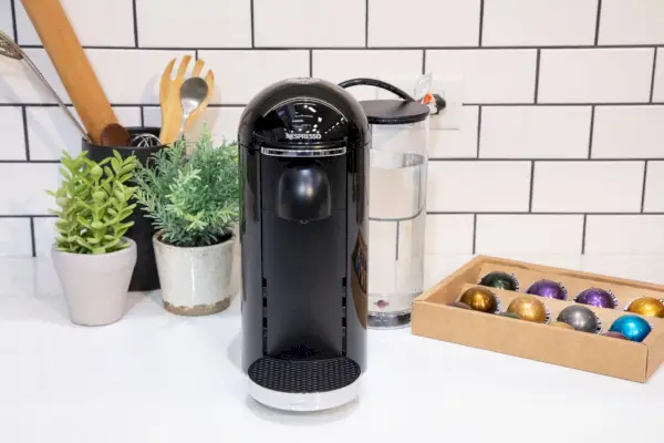 Nespresso VertuoPlus Deluxe od Breville na kuchyňské lince poblíž krabice s kapslemi