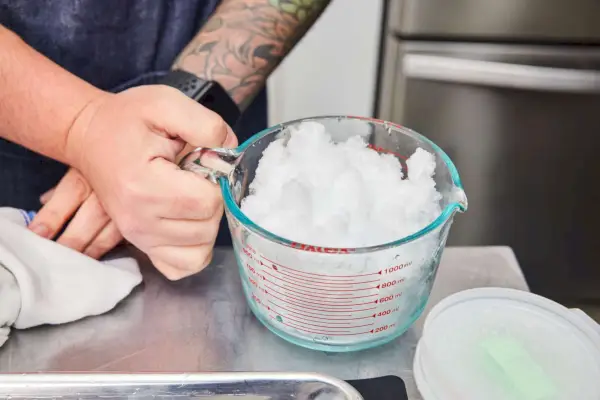 Der Messbecher enthält Eis aus der Hawaiian HomePro Shave Ice and Snow Cone Machine