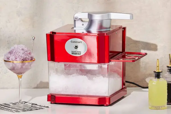 Cuisinart Snow Cone Maker (SCM-10P1) mit Eisportionierer und Marmeladenflaschen auf dem Tisch platziert