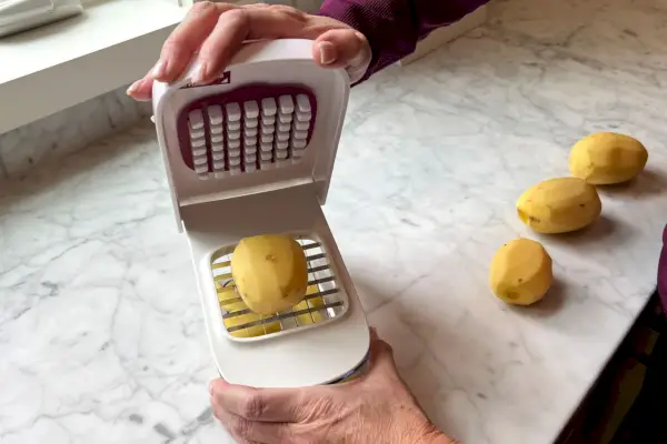 Osoba krájející brambory OXO Veggie Chopper