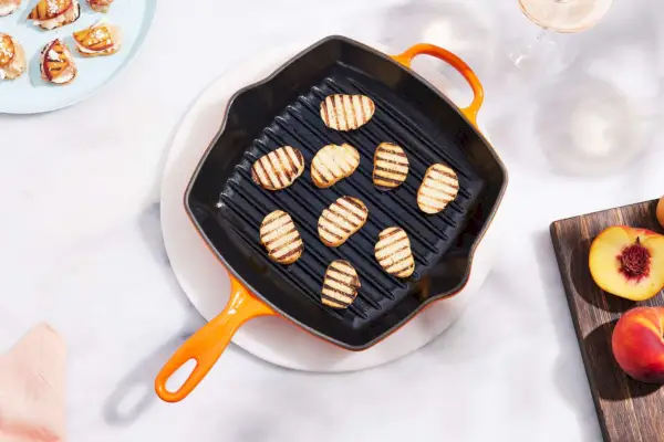 Die emaillierte Gusseisen-Grillpfanne von Staub auf einem Tisch mit gegrilltem Brot in der Pfanne.