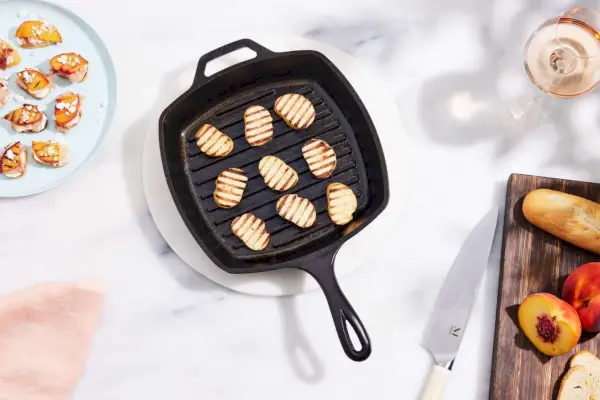 Die gewürzte quadratische Grillpfanne aus Gusseisen von The Lodge mit gegrillten Toastscheiben darin.