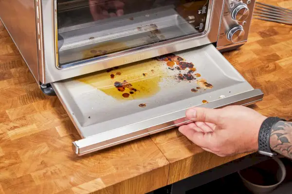 Breville スマート オーブン エア フライヤーから汚れた部分を取り除く手