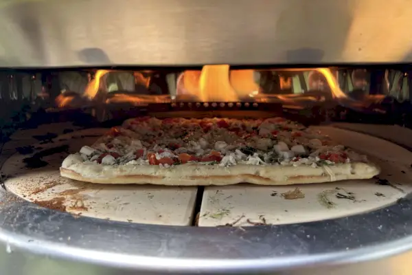 Zamrożona pizza umieszczona w oświetlonym piecu do pizzy Solo Stove Pi Prime.