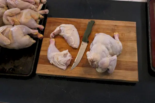 Benchmade Meatcrafter, 6 pouces avec cuisse de poulet tranchée sur une planche à découper