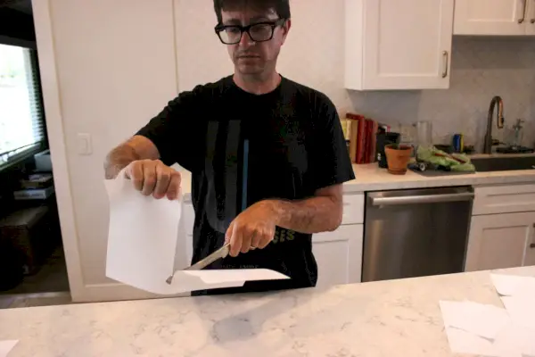 Personne utilisant un couteau de boucher lourd Global GF-27-7 de 7 pouces pour couper du papier