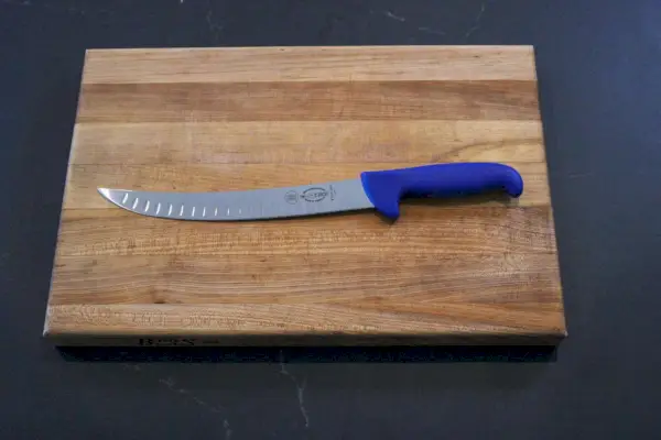 Couteau à briser F. Dick de 10 pouces, sol creux sur planche à découper