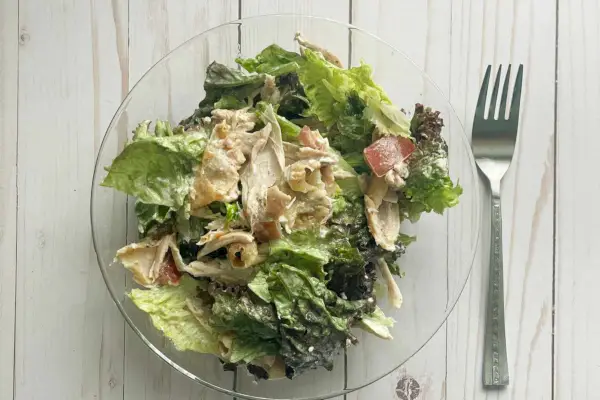 Insalata del mercato dei disadattati seduta nella ciotola accanto alla forchetta sul tavolo