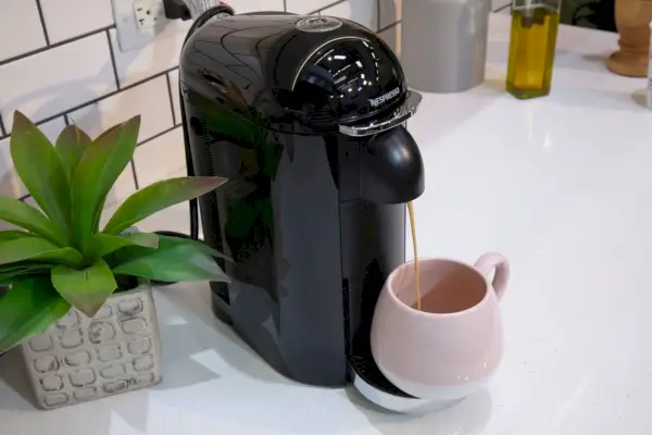 O Nespresso VertuoPlus Deluxe da Breville distribui café expresso em uma caneca