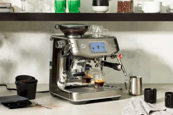 Máquina de café expresso Breville Barista Touch Impress com moedor preparando um café expresso em um balcão