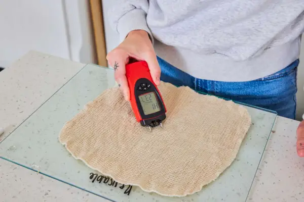 Osoba provádí test na listu omyvatelných papírových ručníků Mioeco.