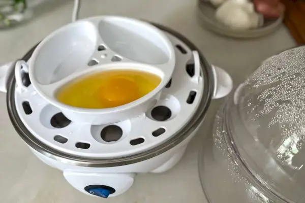 Dash Deluxe Rapid Egg Cooker se syrovým vejcem uvnitř