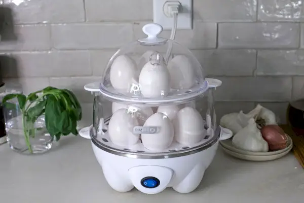 Dash Deluxe Rapid Egg Cooker plněný celými vejci na kuchyňské lince