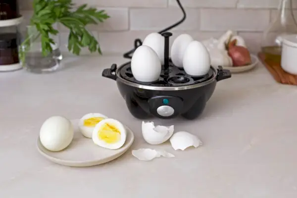 Dash Rapid Egg Cooker sedí na kuchyňské lince a vaří celá vejce