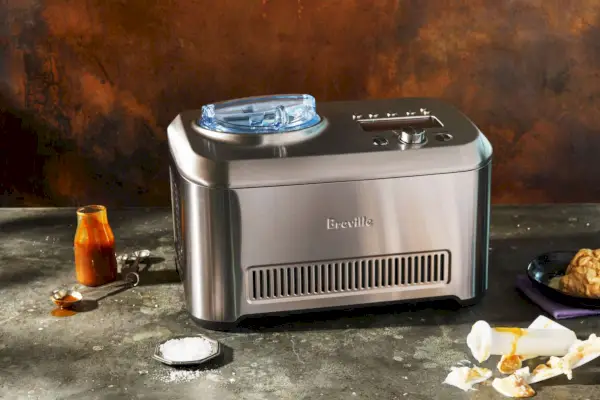 Breville The Smart Scoop Ice Cream Maker vystavený na pulte vedľa zásob na výrobu zmrzliny