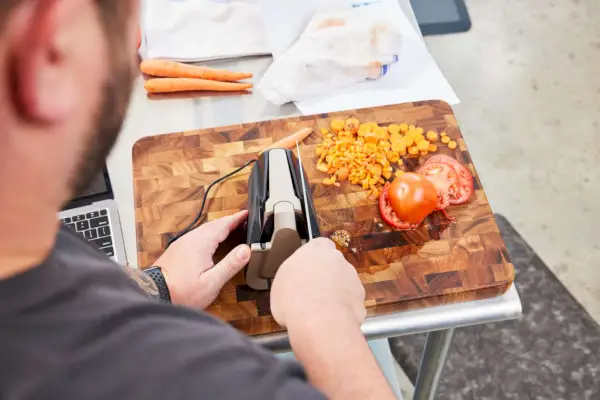 אדם המשתמש ב-Work Sharp Culinary E5 משחיז סכינים להשחזת סכין
