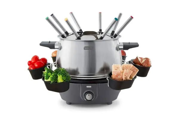 Dash Deluxe Fondue Maker s rôznymi jedlami na podnosoch