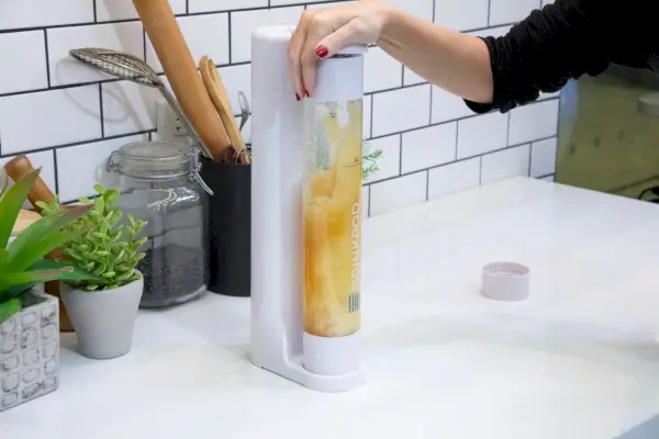 Osoba stlačí tlačidlo na Drinkpod Fizzpod