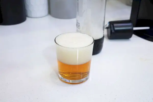 Na obrázku je pohár sýtenej sódy vyrobený v zariadení na výrobu perlivej vody a sódy Drinkmate OmniFizz