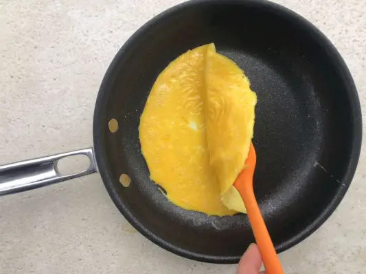 Mit dem Spatel zusammenklappbares Omelette in einer antihaftbeschichteten Bratpfanne Insignia TITUM von Thomas Keller