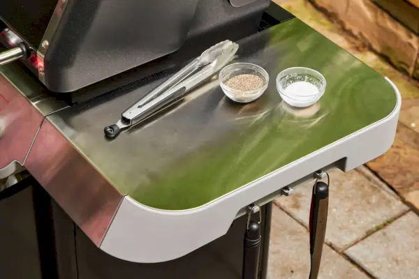 Temperos e pinças na mesa lateral da churrasqueira a gás propano líquido Weber Genesis E-325