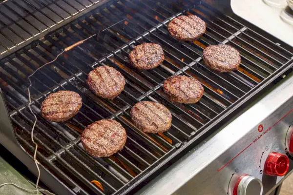 A carne é cozida na churrasqueira a gás propano líquido Weber Genesis E-325