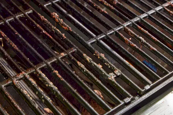Resíduos de alimentos deixados na churrasqueira a gás propano líquido Weber Genesis E-325 após o uso