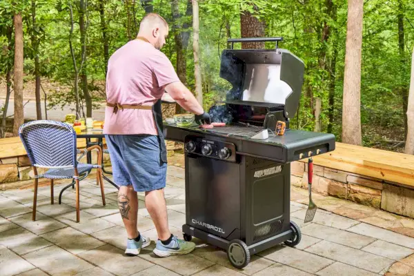 Uma pessoa cozinha carne na churrasqueira a gás Char-Broil 463365124 Pro Series 3 Burner