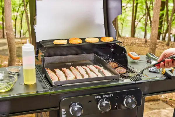 Os alimentos são cozidos na churrasqueira a gás Char-Broil 463365124 Pro Series 3 Burner