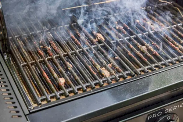 Os resíduos de alimentos que sobraram do cozimento na churrasqueira a gás Char-Broil 463365124 Pro Series 3 Burner
