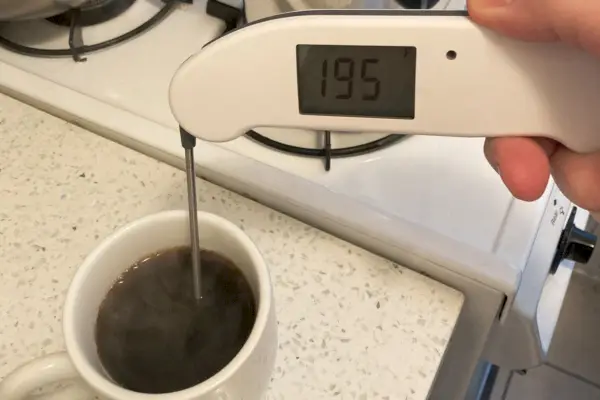 Osoba kontroluje teplotu kávovaru Farberware Stainless Steel Yosemite Coffee Percolator