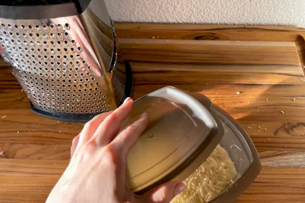 Ruka držiaca uzáver KitchenAid Gourmet strúhadla z nehrdzavejúcej ocele s odnímateľnou úložnou nádobou