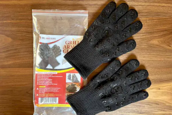 Ekstremalnie odporne na ciepło rękawice grillowe Grill Heat Aid są wyświetlane na drewnianym stole