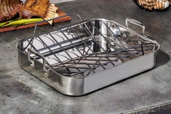 회색 카운터에 붙지 않는 랙이 있는 Le Creuset 스테인리스 스틸 로스팅 팬
