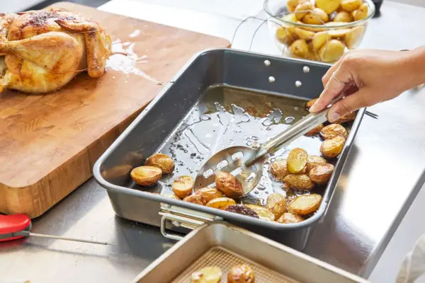Farberware Nonstick Steel Roaster with Flat Rack에서 구운 감자를 픽업하고 있습니다.