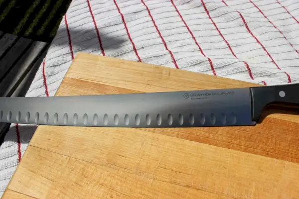 Eine Nahaufnahme der gezackten Kante des Wüsthof Gourmet 14-Zoll-Brustmessers mit hohler Kante