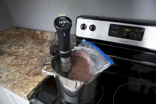 Steak in einer Plastiktüte mit dem Anova Culinary Sous Vide Precision Cooker in einem Topf auf dem Herd