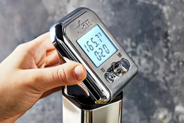 Nahaufnahme einer Hand, die einen All-Clad Sous Vide Professional Zirkulator hält