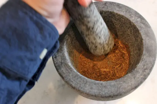 Osoba testující Tera sadu malty a paličky z leštěné žuly