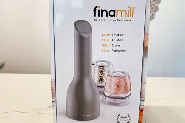 Mlýnek na pepř a koření FinaMill v krabici umístěné na mramorové desce