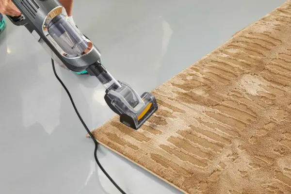 リバイバルシェルウォッシャブルラグに掃除機をかけている人