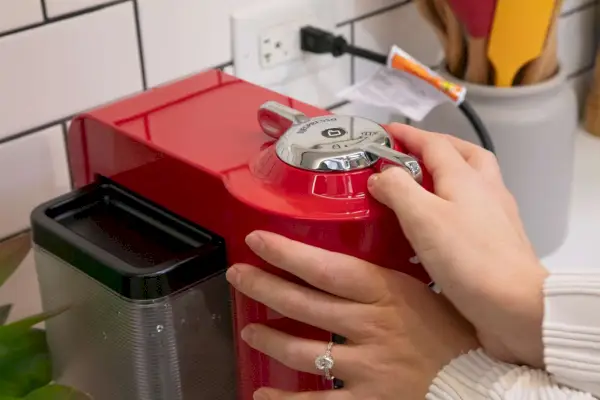 Osoba reguluje Nespresso Evoluo