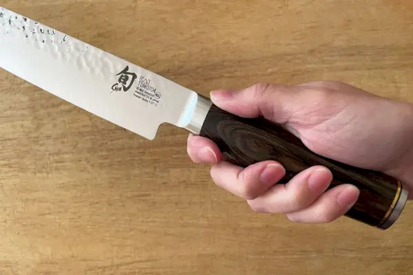 Mano sosteniendo el cuchillo de trinchar Shun Premier